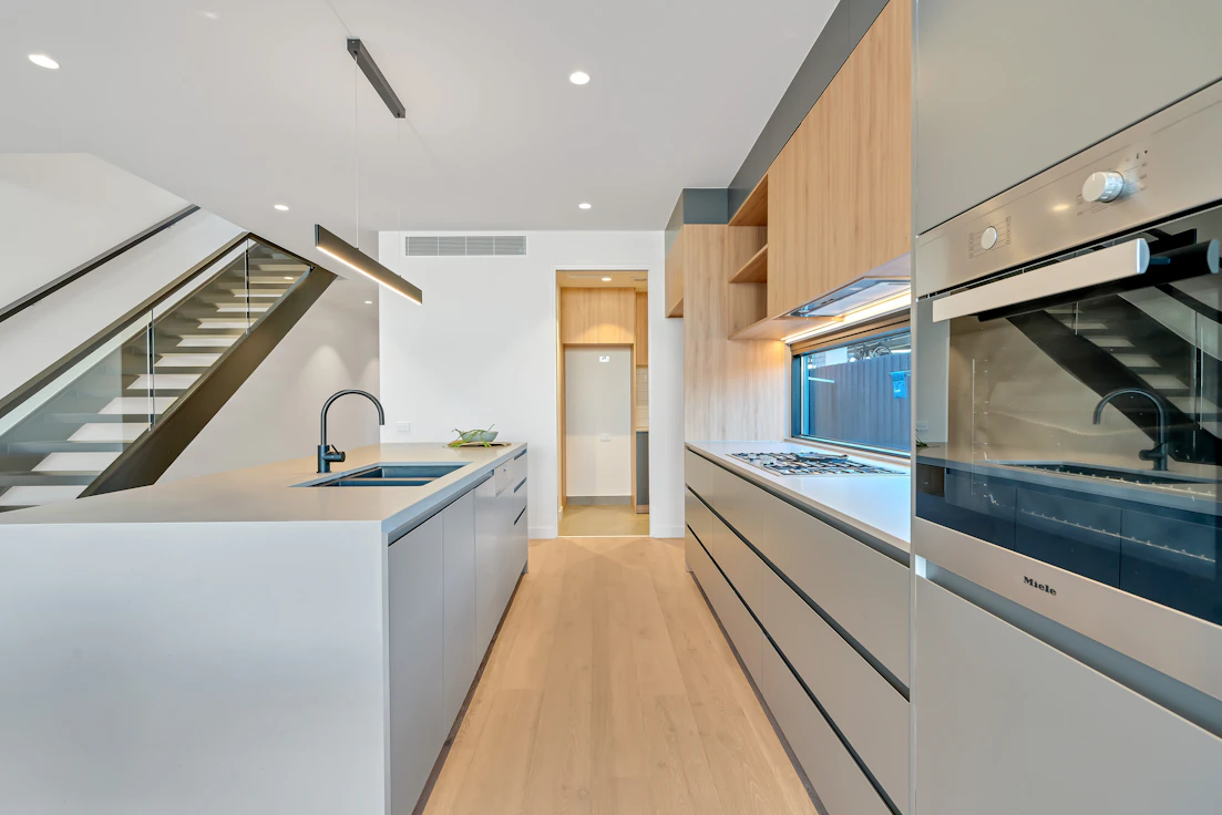 brown wooden parquet floor and white wooden kitchen cabinet