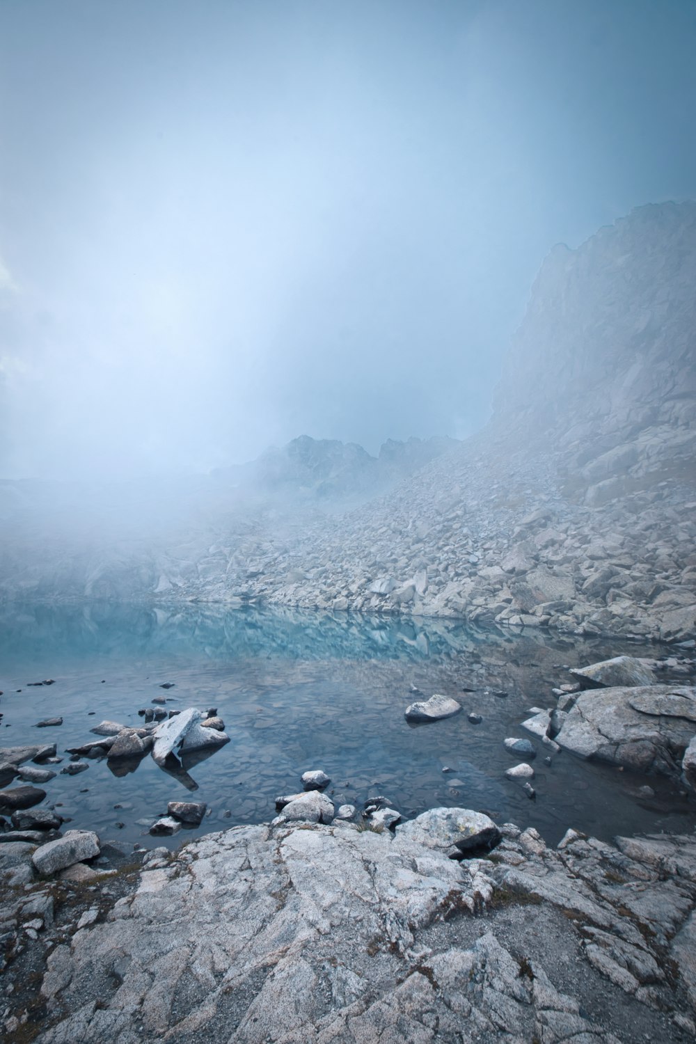 a river surrounded by rocks and snow covered mountains