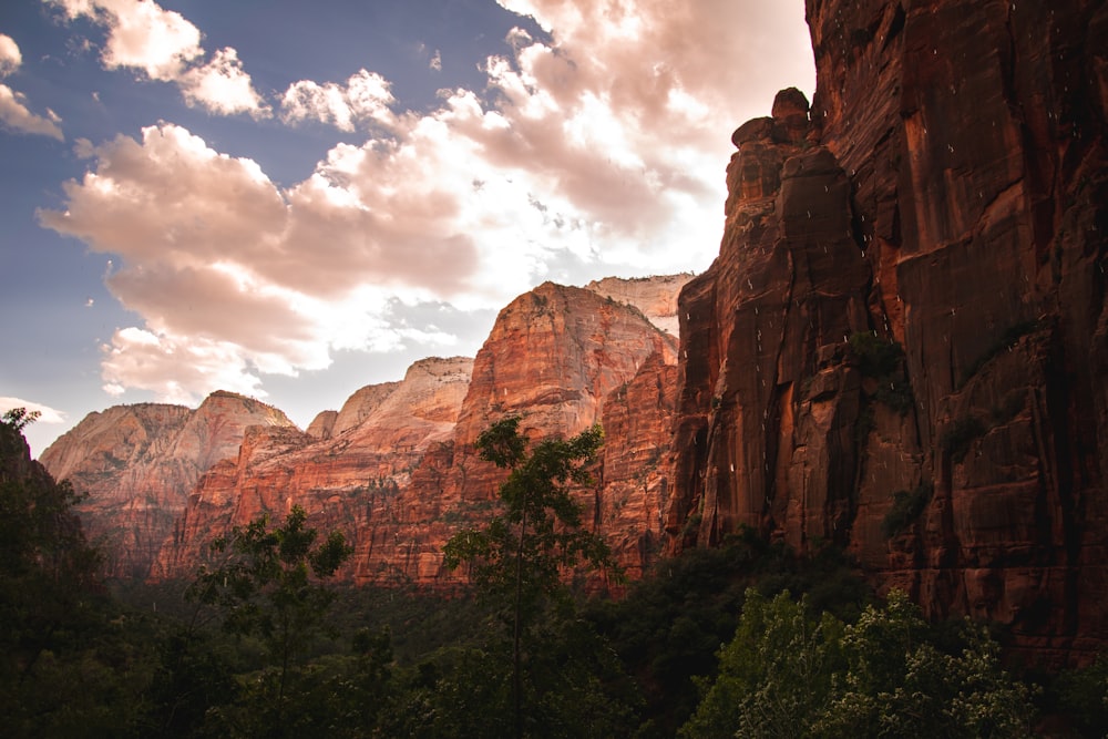 brown rocky mountain under blue sky and white clouds during daytime