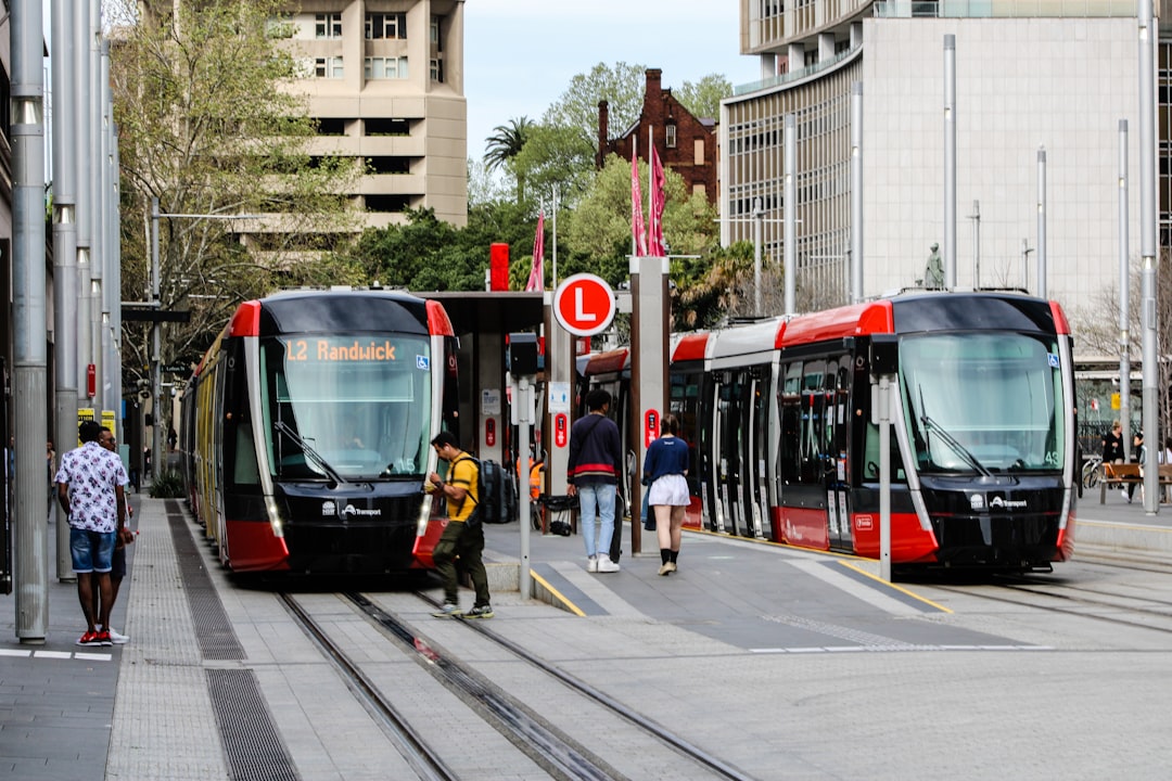 people standing near red and white tram during daytime