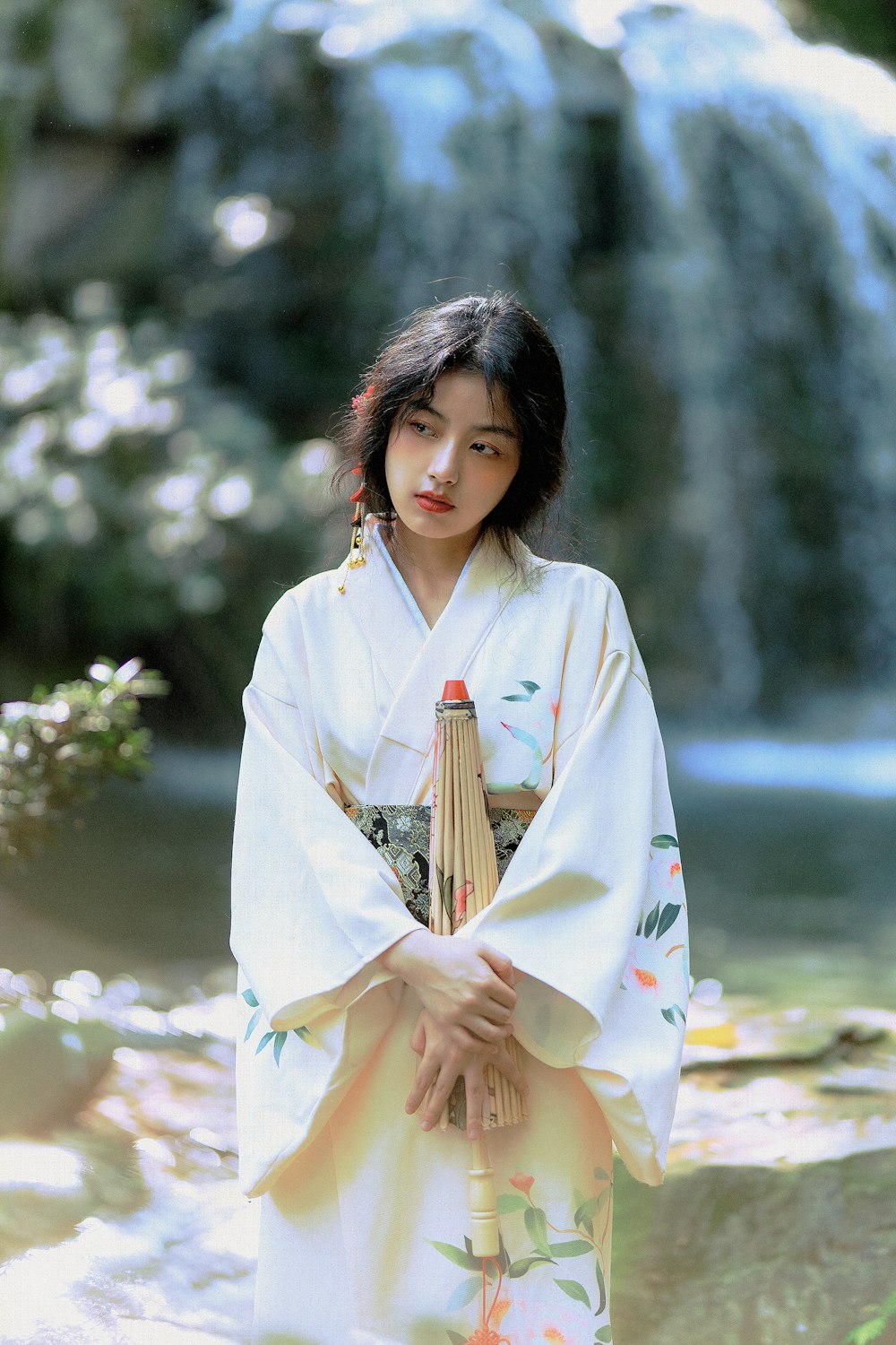 Femme en kimono blanc debout près de fleurs blanches pendant la journée