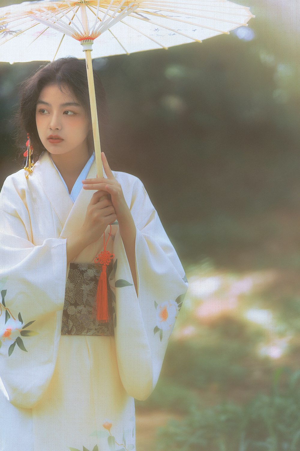 woman in white and red floral kimono holding brown wooden stick