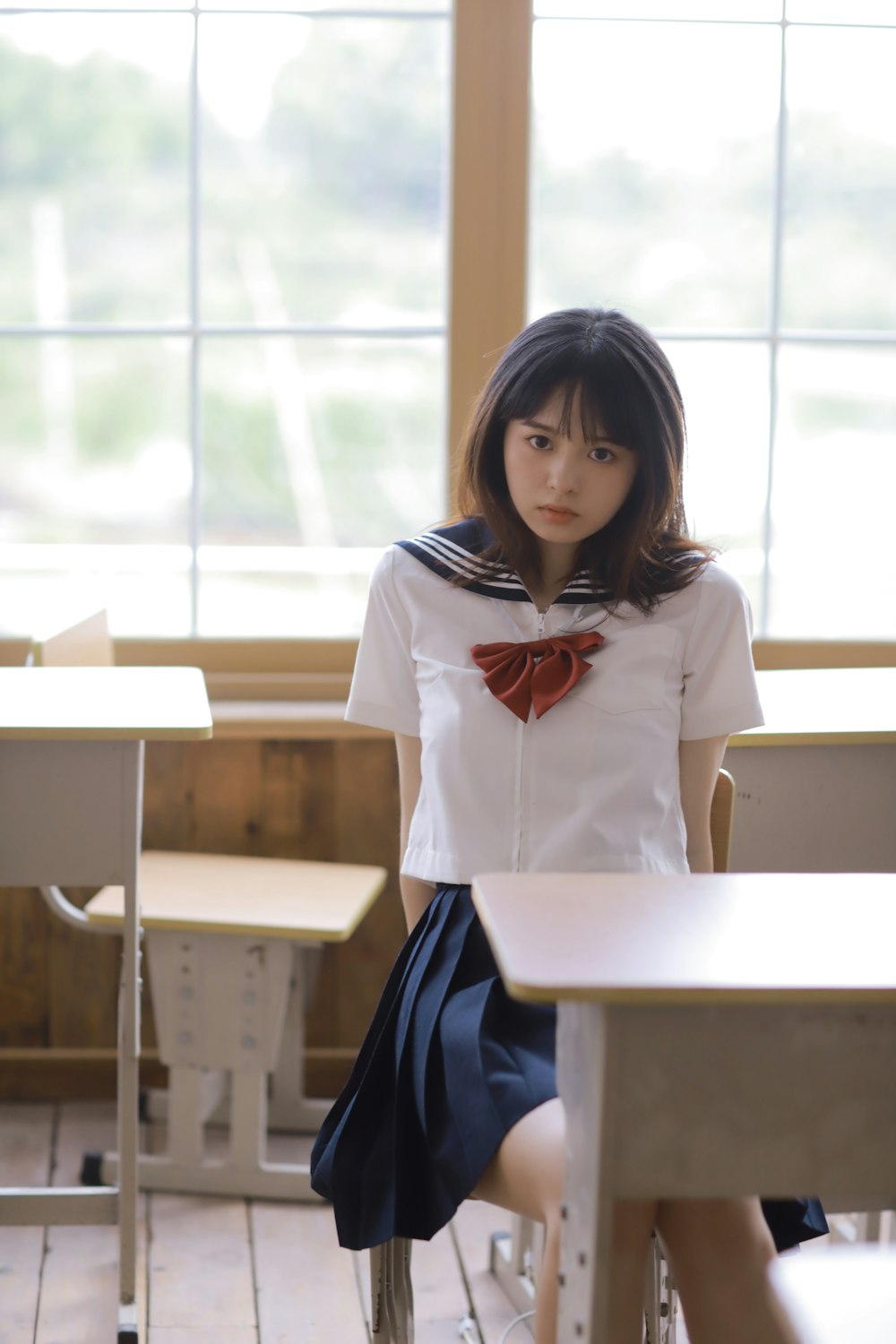 girl in white and red school uniform sitting on chair