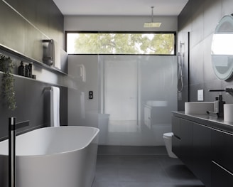 white ceramic bathtub near white bathtub