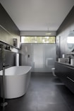 white ceramic bathtub near white bathtub