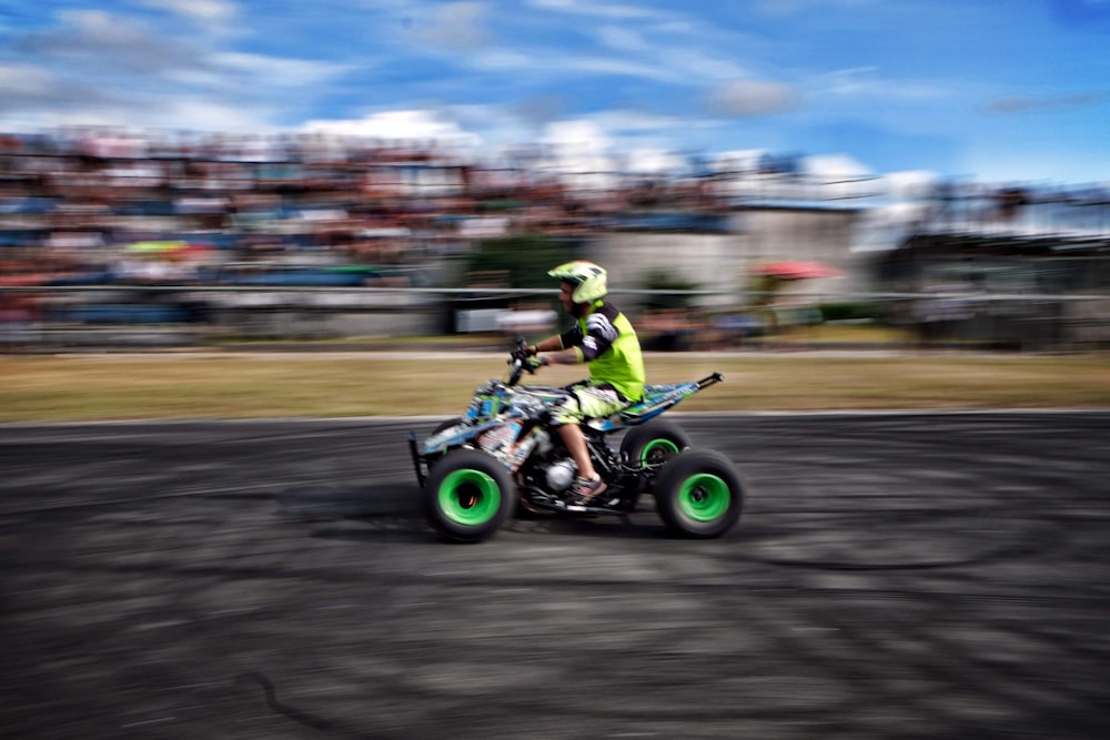 man riding green atv on road during daytime