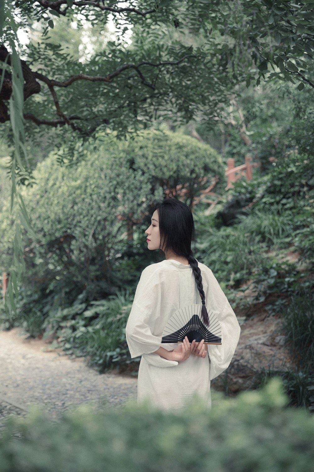 woman in white long sleeve shirt standing near green plants during daytime