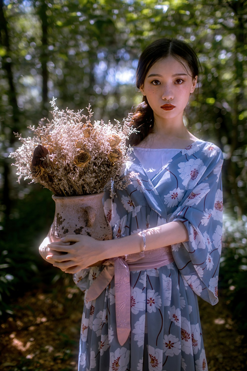 woman in blue and white floral dress holding brown wicker basket