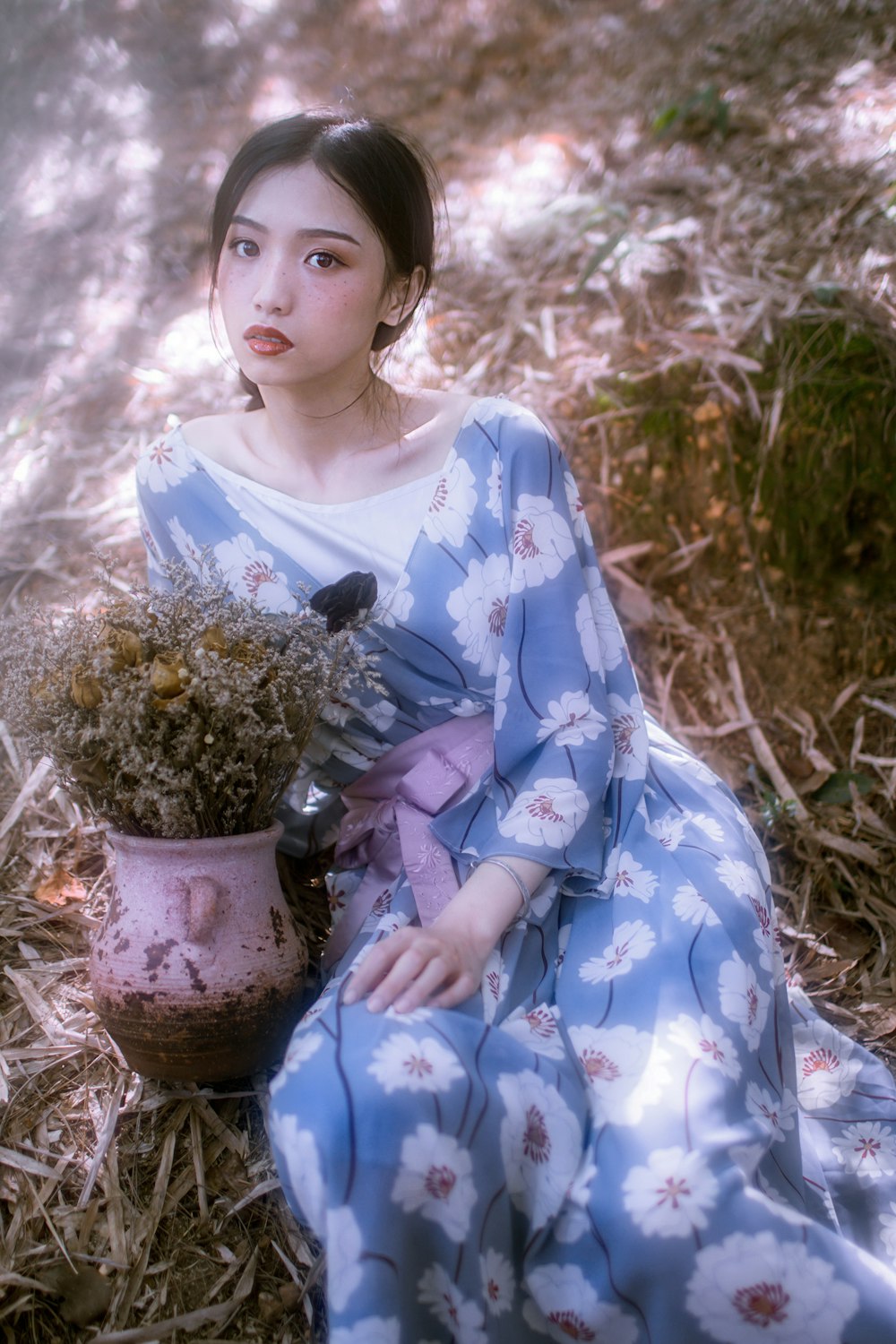 woman in blue and white floral dress holding white flower bouquet