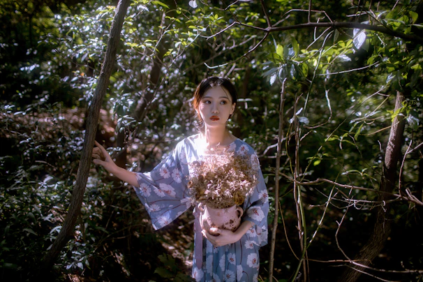 Sunlit indigenous healer preparing botanical remedies surrounded by lush forest greenery.
