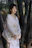 A serene photo of a person sitting quietly among tall bamboo stalks at dawn.