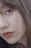 Close-up of a person's face focusing on the eye and lips, featuring natural makeup with brown lipstick. The skin appears smooth and the hair is brown, slightly covering part of the face.