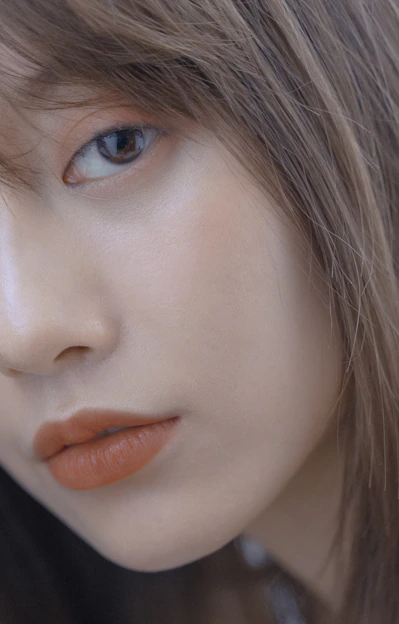 Close-up of a natural makeup look featuring glowing skin, soft eyeshadow, and subtle lip color.
