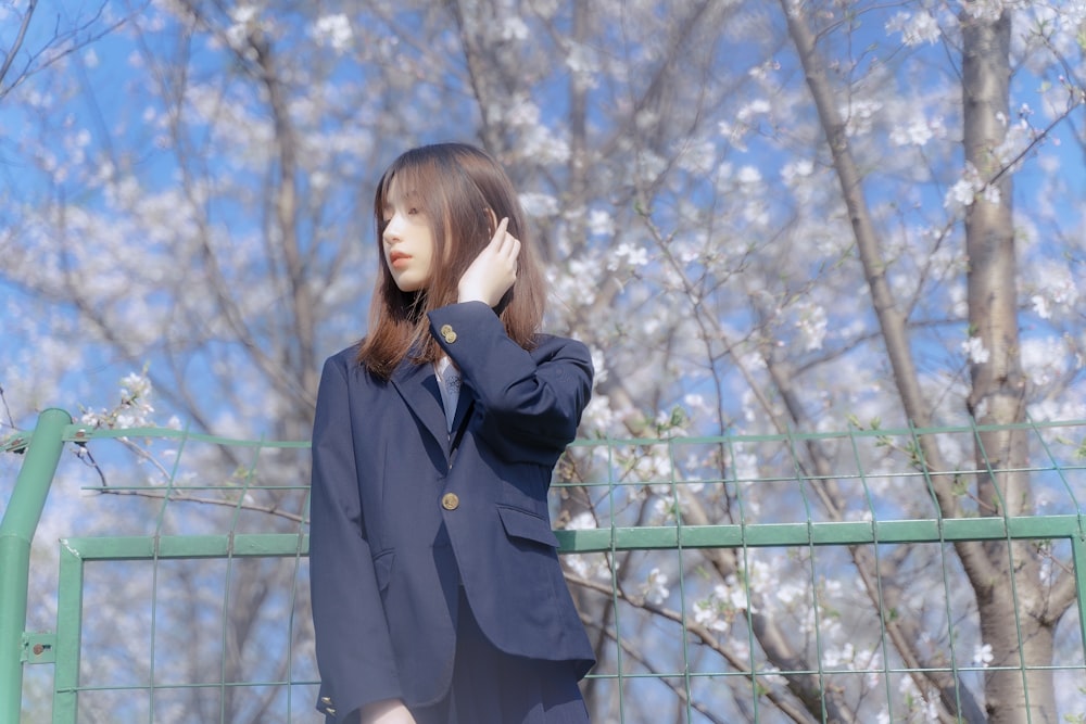 woman in black coat standing near brown trees during daytime