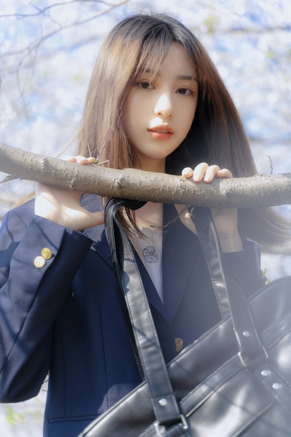 woman in blue and white school uniform holding brown wooden stick