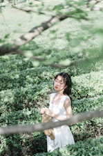 A serene woman meditating outdoors at sunrise, surrounded by soft natural light and gentle greenery.