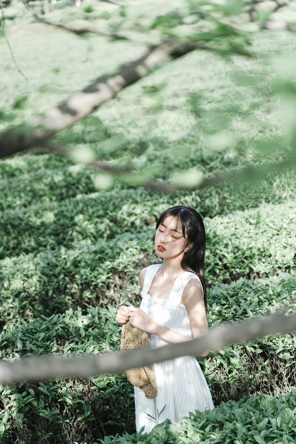 woman in white sleeveless dress holding brown woven basket