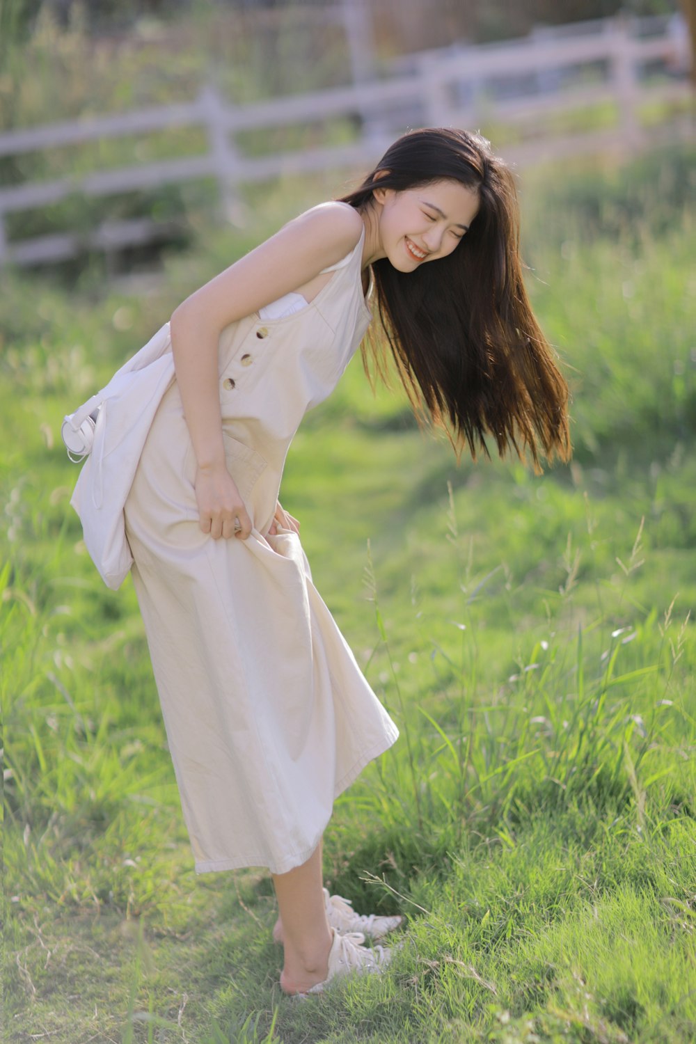 woman in white long sleeve dress standing on green grass field during daytime