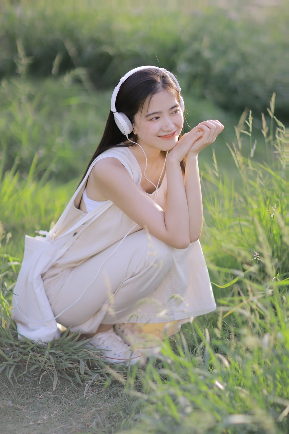 woman in white dress sitting on grass field