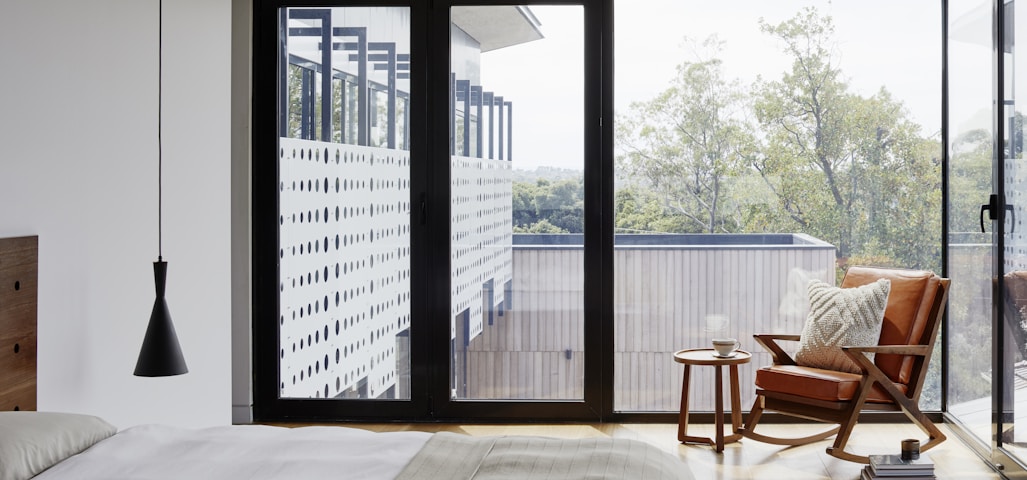 brown wooden armchair near glass window