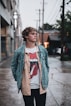 man in gray jacket standing on sidewalk during daytime