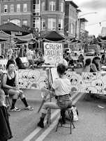 An artist showcasing a finished caricature to an excited crowd.
