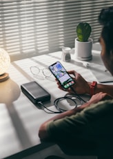 person holding black smartphone on white textile