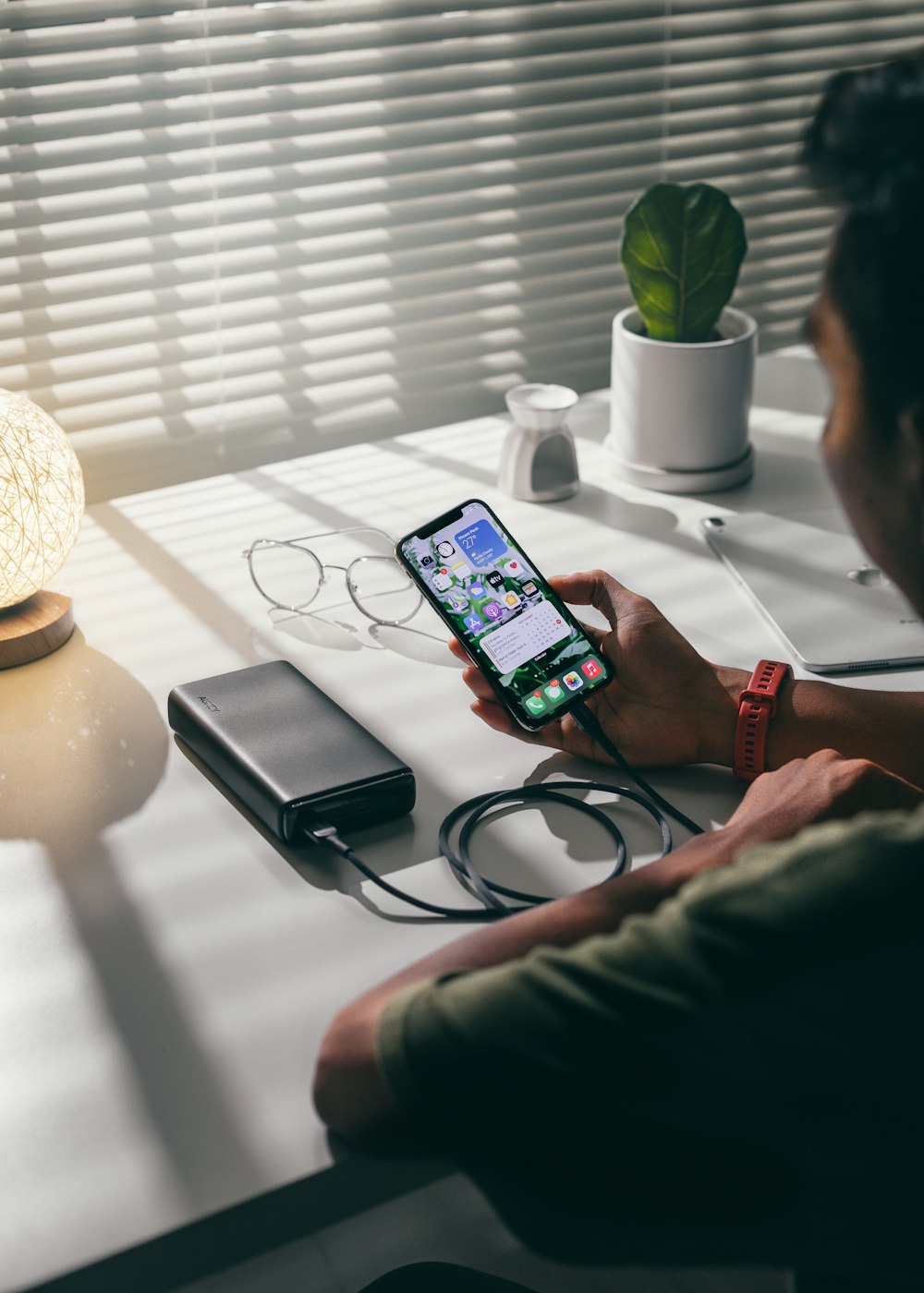 person holding black smartphone on white textile