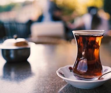 a cup of tea on a saucer with a spoon