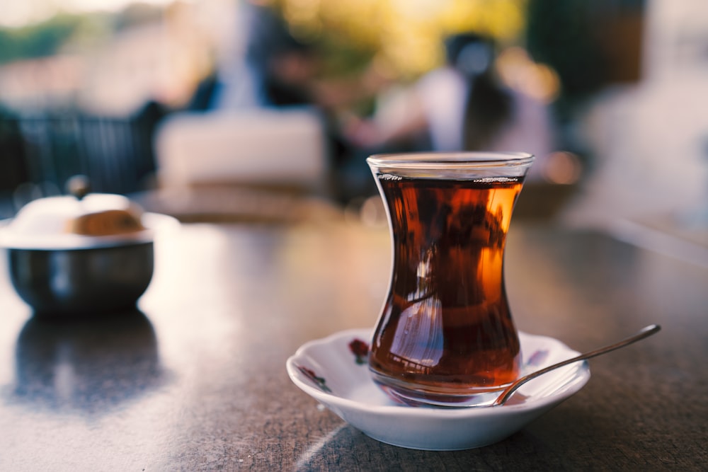 a cup of tea on a saucer with a spoon