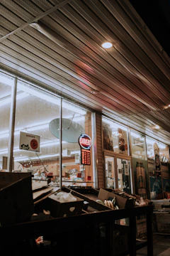 Nighttime exterior shot of a retail store with visible security cameras and lighting.