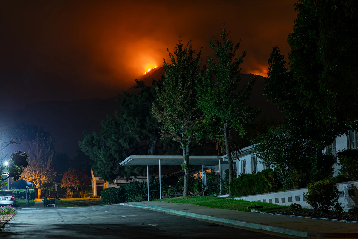 House surrounded by wildfire glow at night