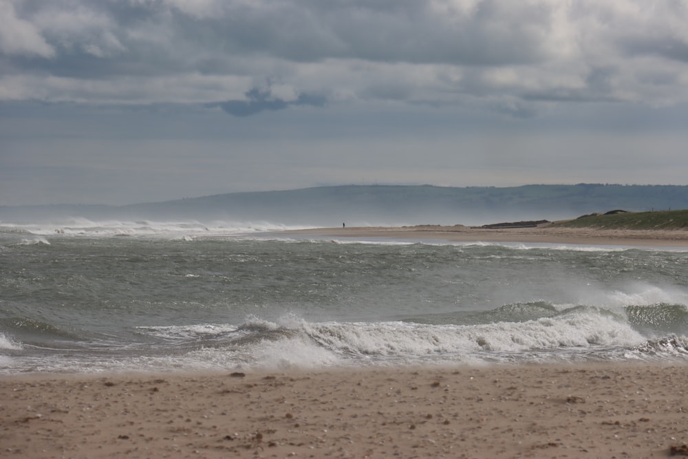 ocean waves crashing on shore during daytime