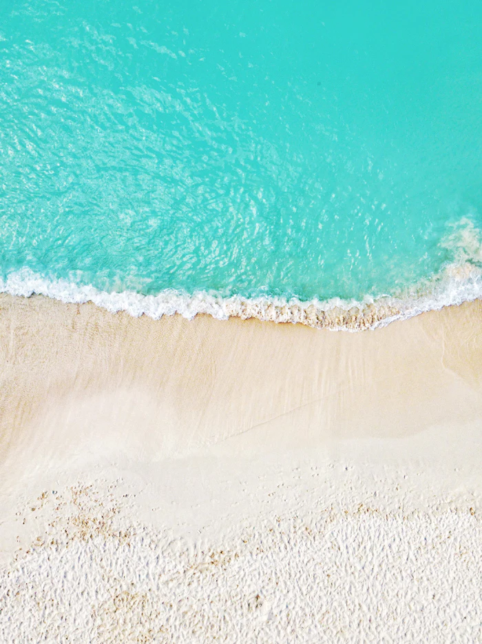 Aerial view of turquoise water and white sand along the Cayman Islands coastline