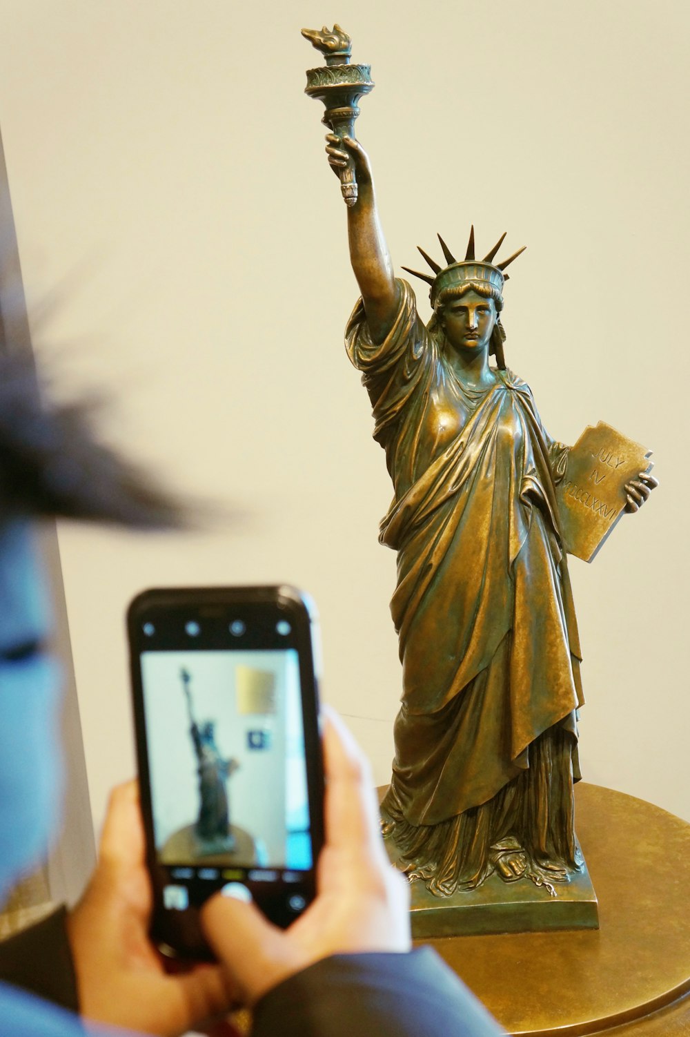 a person taking a picture of a statue of liberty
