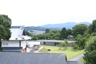 A serene landscape of a traditional heritage site surrounded by lush greenery.