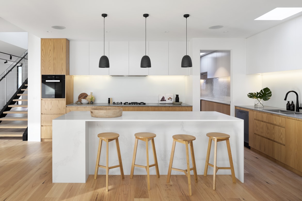 a minimalist kitchen with white, black, and brown furnishings