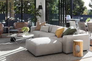A spacious sectional sofa in a bright, airy room with colorful pillows and a coffee table.
