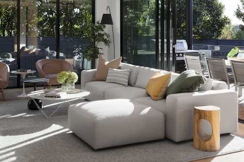 A spacious sectional sofa in a bright, airy room with colorful pillows and a coffee table.