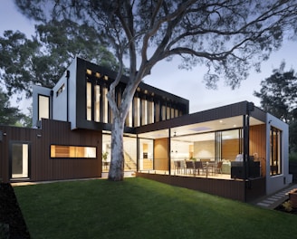 brown and white wooden house near green trees during daytime