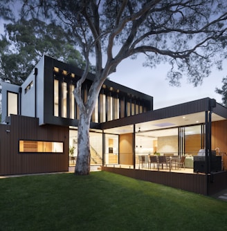 brown and white wooden house near green trees during daytime