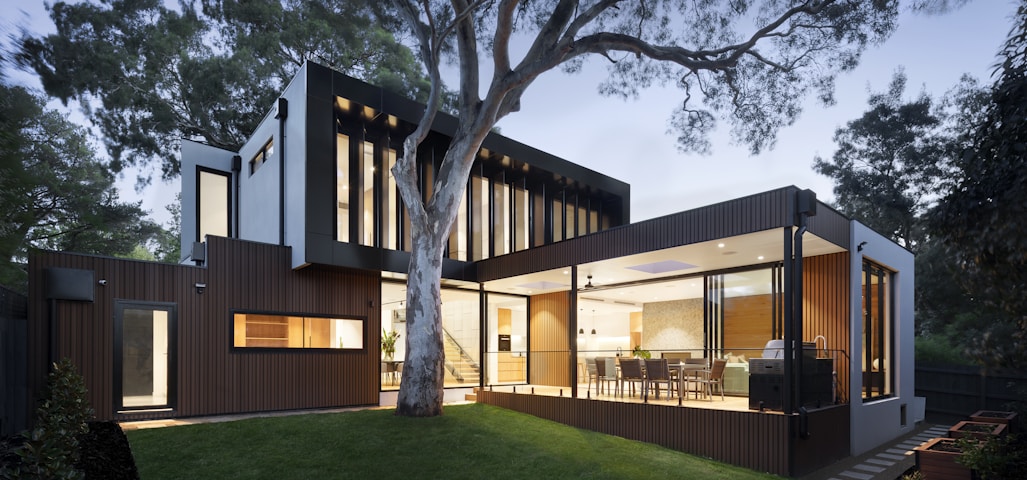 brown and white wooden house near green trees during daytime