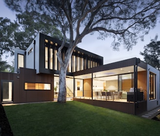 brown and white wooden house near green trees during daytime