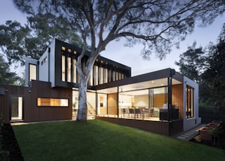 brown and white wooden house near green trees during daytime