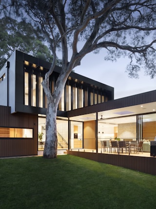 brown and white wooden house near green trees during daytime