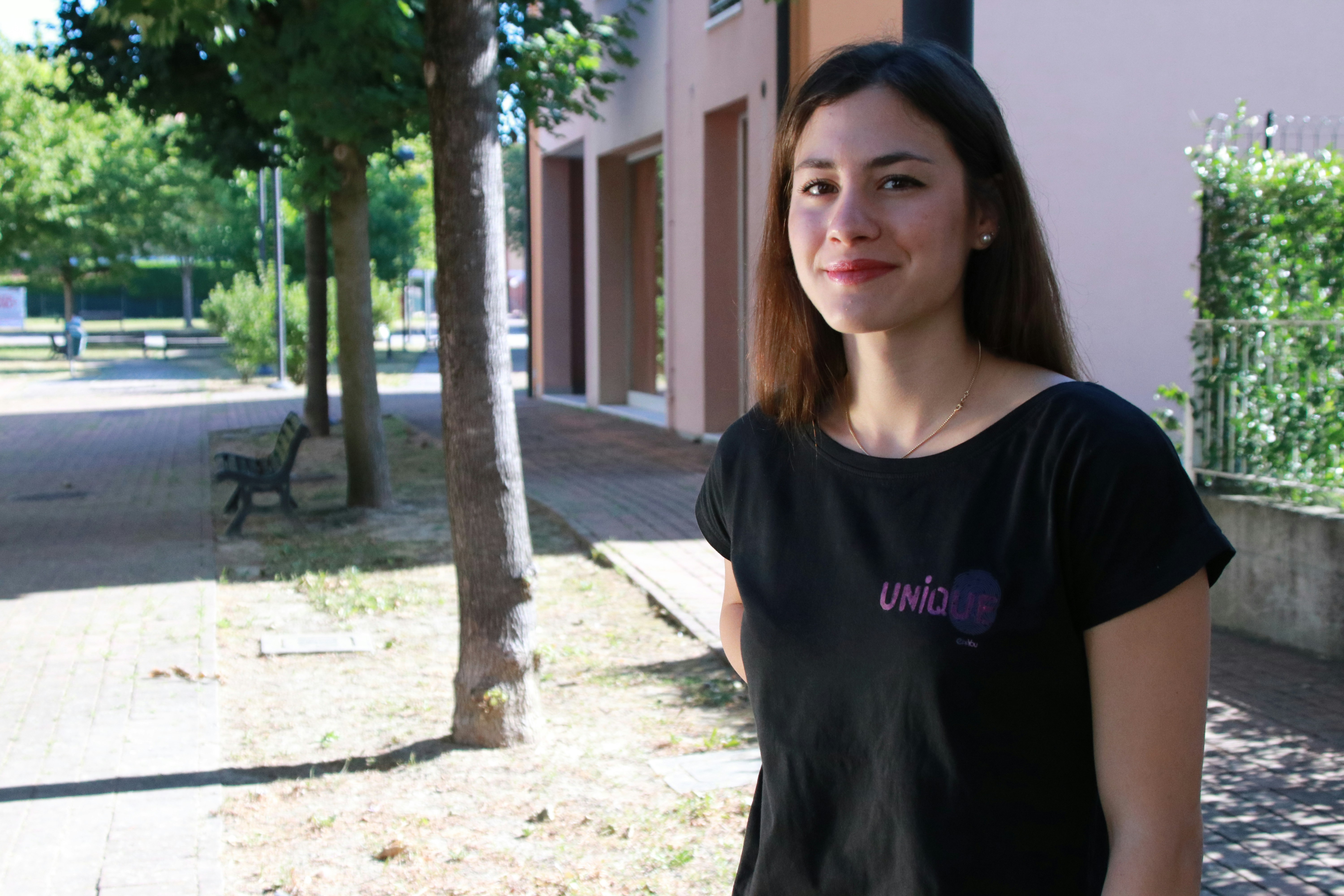 woman in black crew neck t-shirt standing near tree during daytime