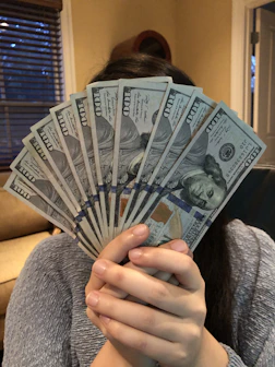 person holding fan of us dollar bill