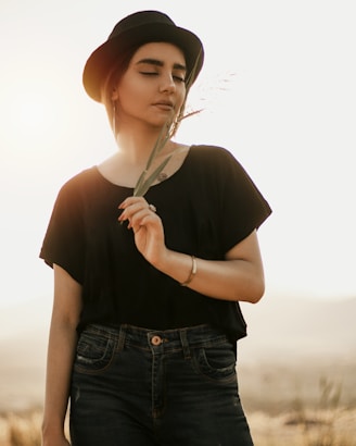 woman in black shirt and blue denim jeans holding white umbrella