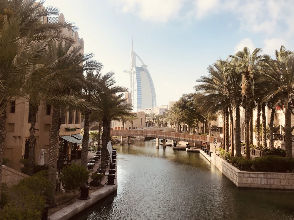 The Burj Al Arab above palm trees and a canal in Dubai