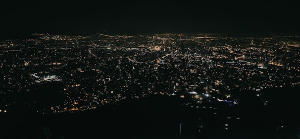 A panoramic view of a bustling cityscape at night, alive with vibrant energy and glowing lights.
